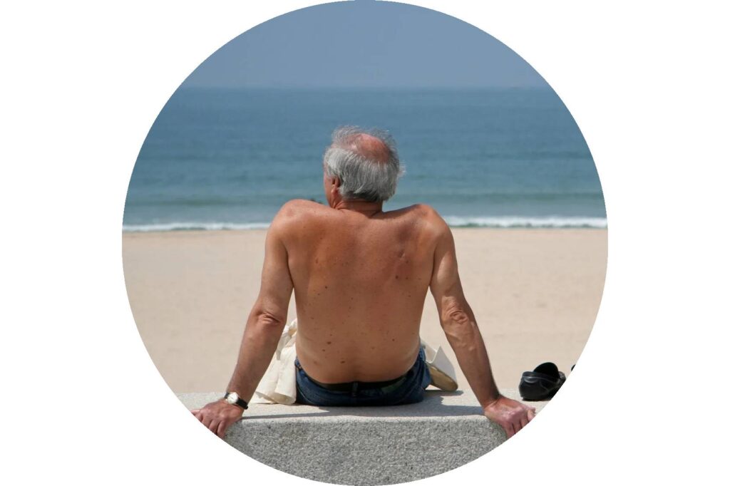 old man sitting on beach